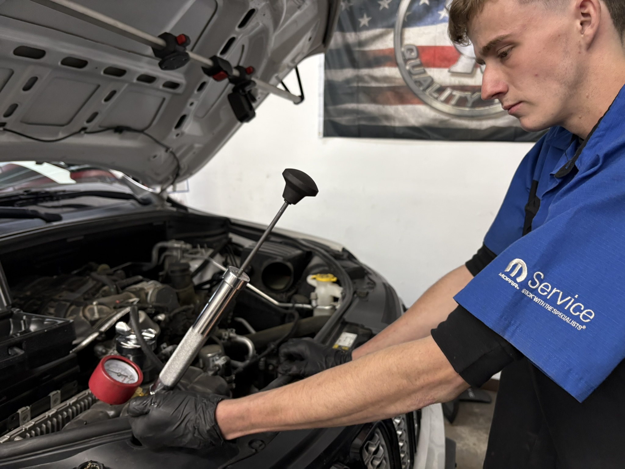 Technician pressure testing a vehicle cooling system
